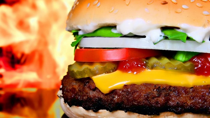 Close-up of a delicious hamburger with flames in the background