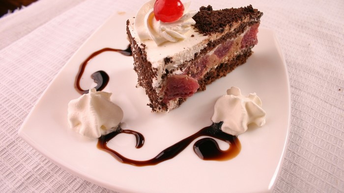 Chocolate cake with cream and cherries
