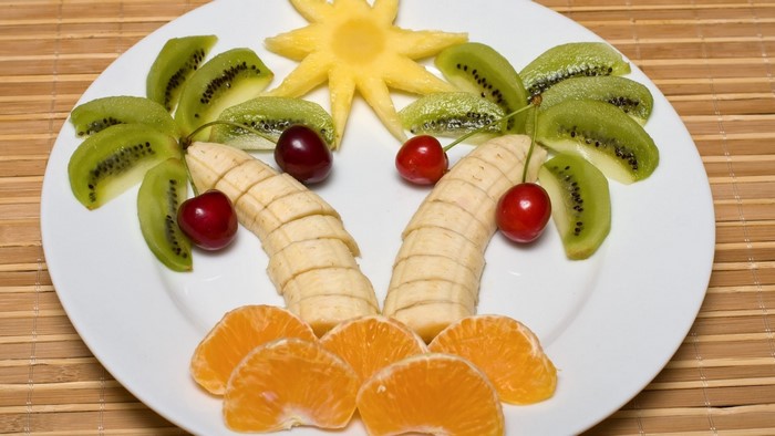Palm tree fruit art on a white plate