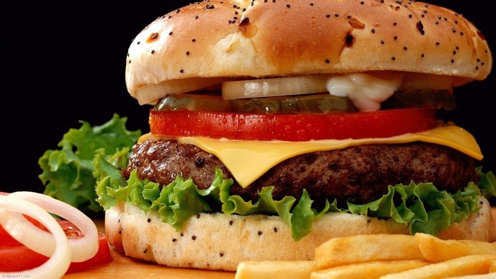 Burger with cheese, lettuce, tomato, onion, pickles, and fries
