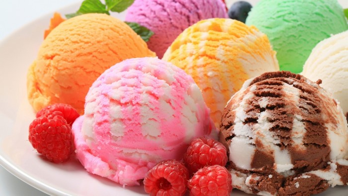 Assortment of colorful ice cream scoops with raspberries