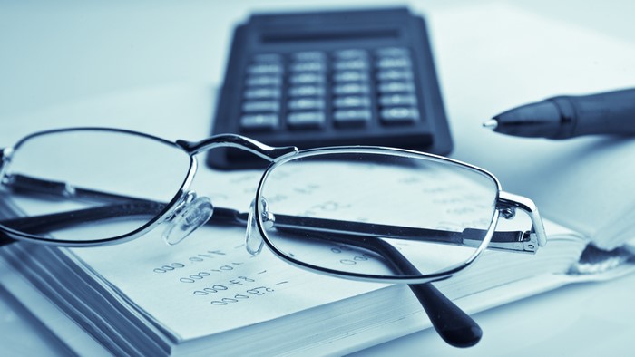 4K Glasses on Book with Calculator and Pen