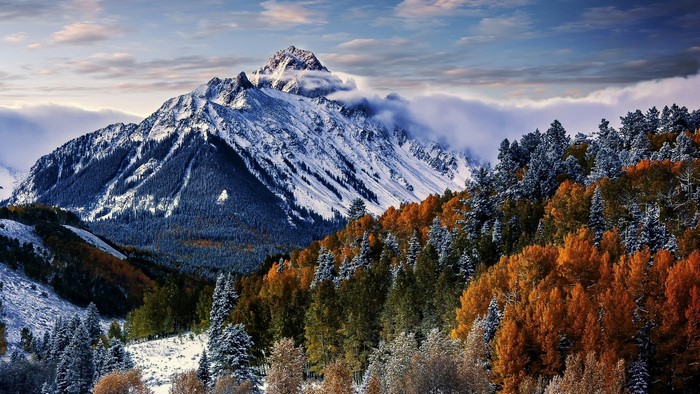 Snow-capped mountain peak with autumn trees