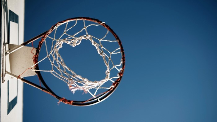 Basketball hoop and net against blue sky