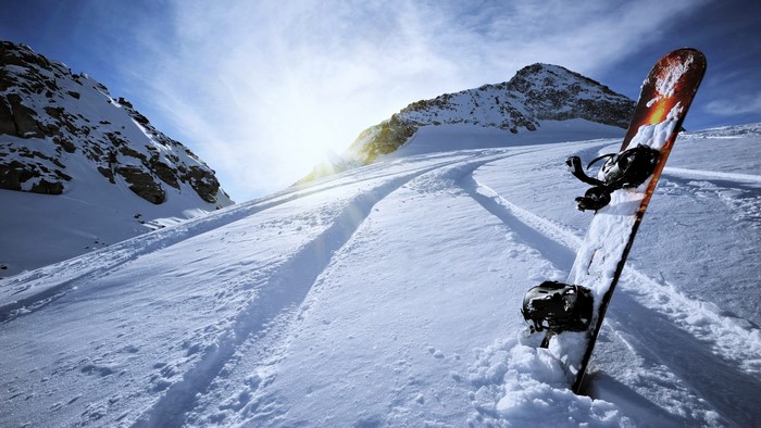 Snowboard leaning in snowy mountain landscape