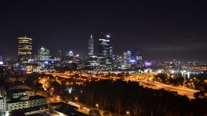 Night skyline of a city with illuminated skyscrapers and highways