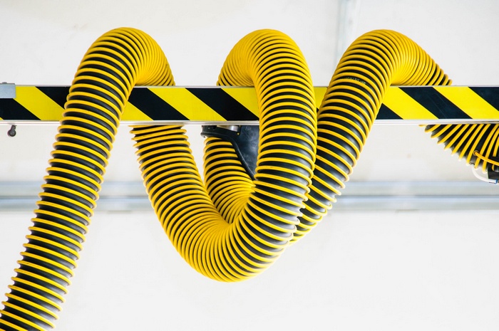 Yellow and black striped flexible hoses hanging from a beam