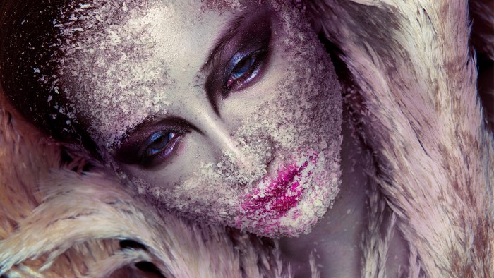 Woman with artistic makeup and feathers
