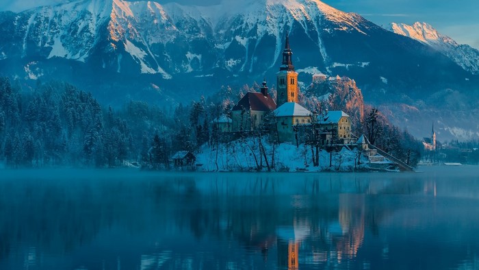 Winter island church and castle with snowy mountains