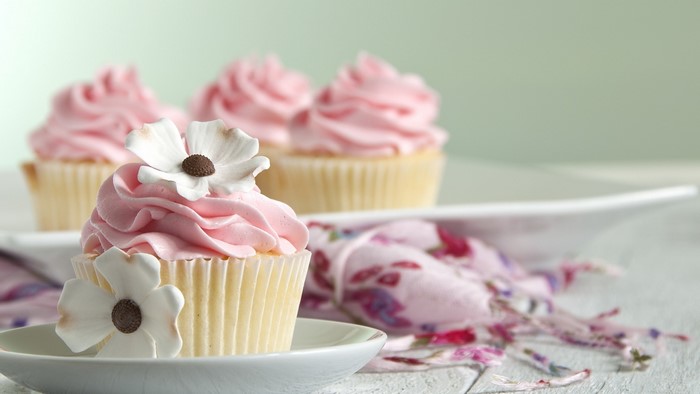 Pink frosted cupcakes with white flowers
