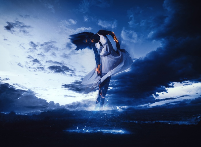 Woman dancing with fire and blue clouds