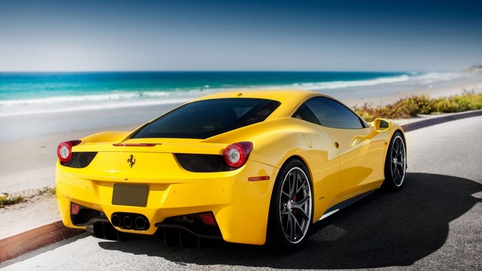 Yellow Ferrari 458 parked by the ocean