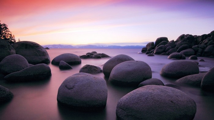 Sunset over a rocky lake shore