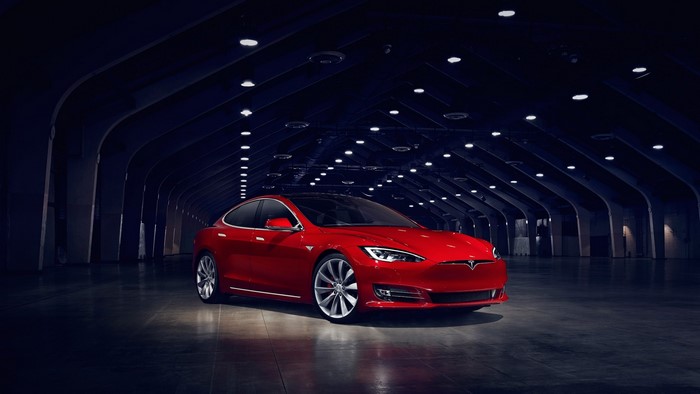 Red Tesla Model S P90d in a dark hall