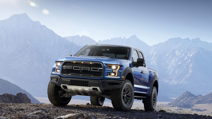 Blue Ford F-150 Raptor truck in mountains