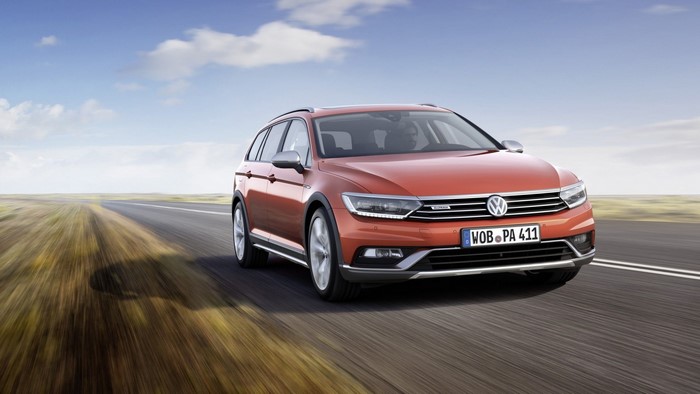 Orange Volkswagen Passat Alltrack driving on a road
