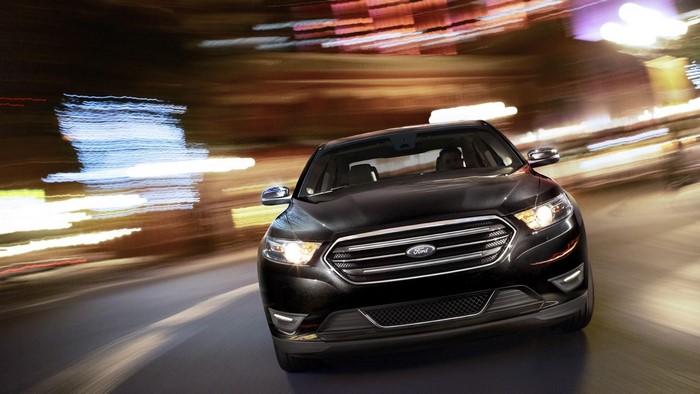 Black Ford Taurus driving at night