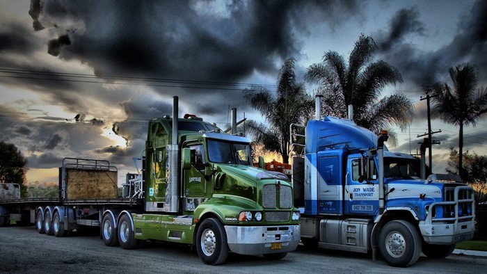 Two trucks parked under a dramatic sky