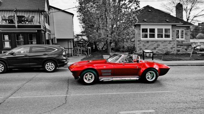 Red convertible classic car driving on a street
