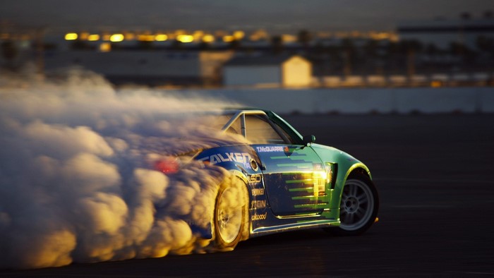 Green drift car performing a burnout