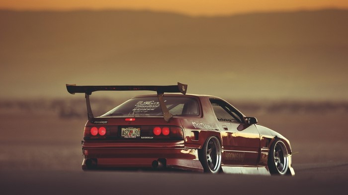 Modified Red Mazda RX-7 with a large rear spoiler