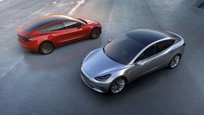Two Tesla Model 3 cars on pavement