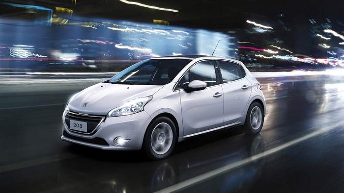 White Peugeot 208 driving at night