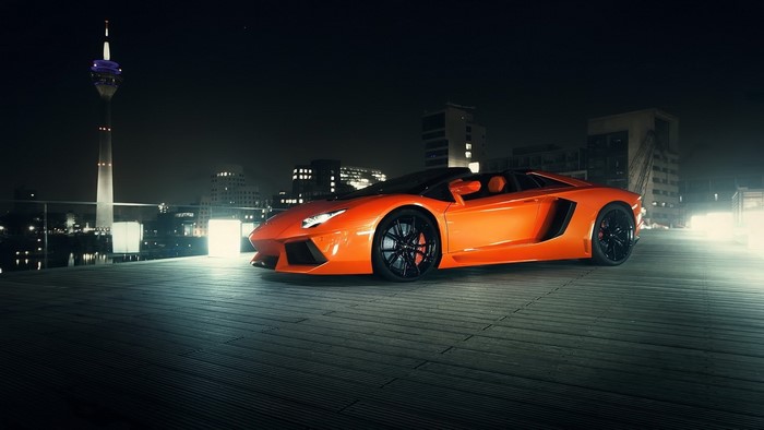 Orange Lamborghini Aventador Roadster at night in city