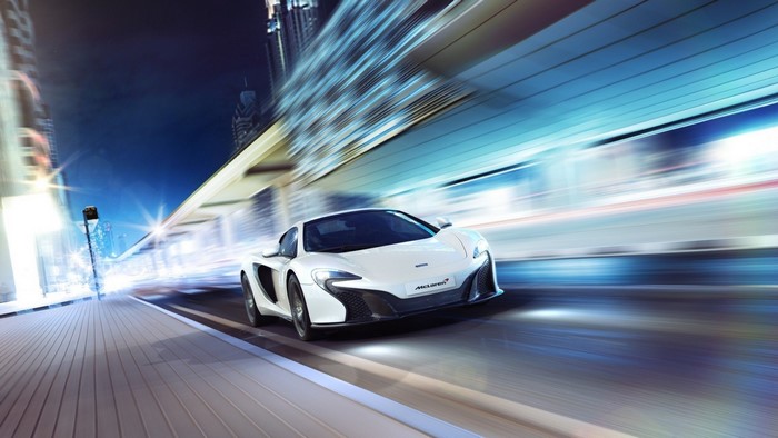 White McLaren driving through a city at night
