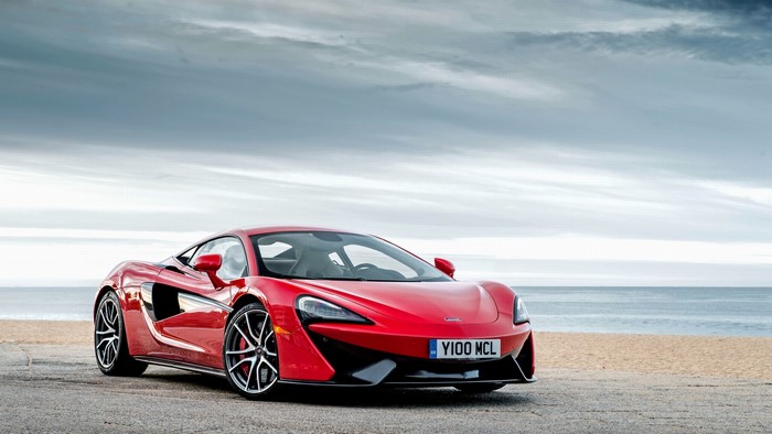 Red McLaren 570S car on a beach