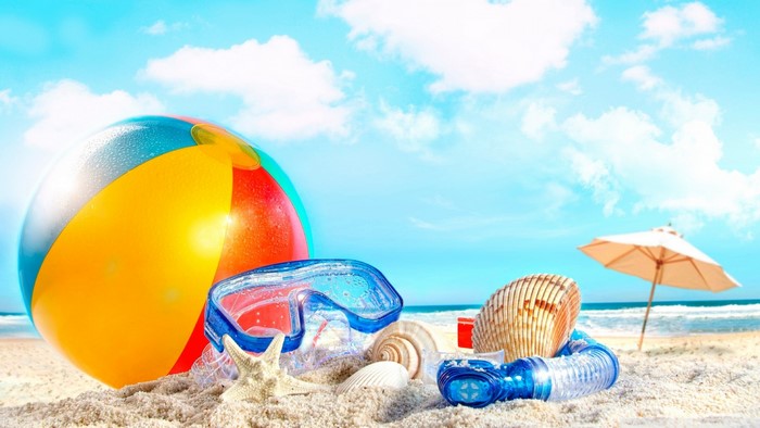 Beach accessories on sand with ocean and sky
