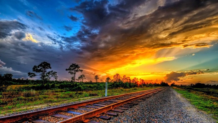 Railroad tracks at sunset with dramatic sky
