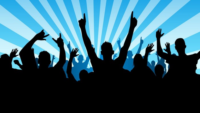 Crowd with hands raised against blue sunburst