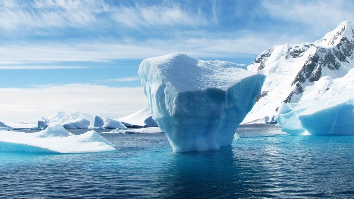 Icebergs floating in the ocean with snowy mountains