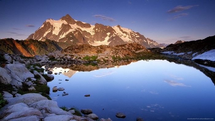 Snow-capped mountains reflected in a calm lake