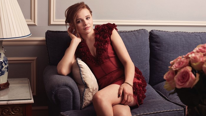 Chloe Grace Moretz sitting on a couch