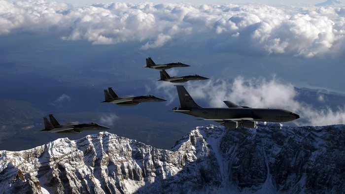 KC-135 Stratotanker and F-15 Eagles flying over mountains