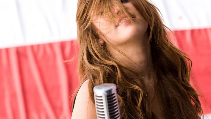 Miley Cyrus singing into a microphone