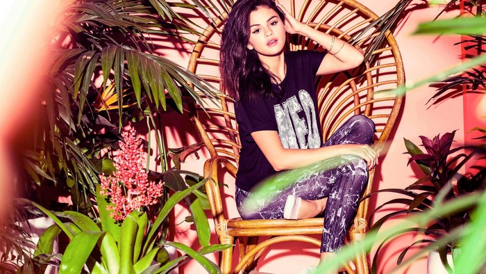 Selena Gomez sitting in a wicker chair
