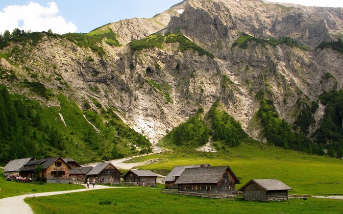 Wooden houses in a mountain valley with green slopes