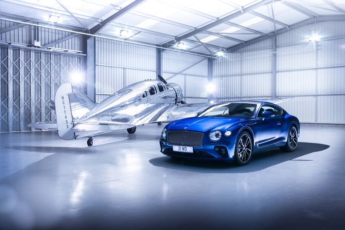 Bentley Continental GT and vintage airplane in hangar
