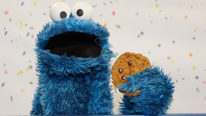 Cookie Monster from Sesame Street holding a cookie