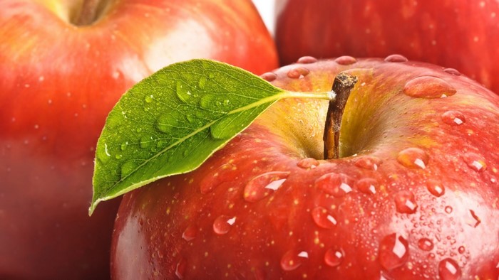 Red apples with water drops and a leaf