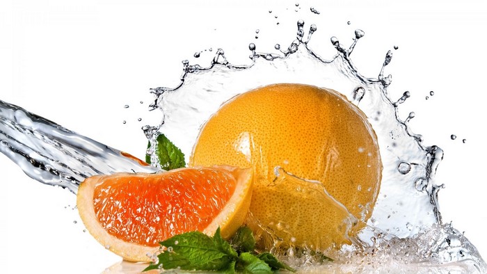 Grapefruit slice and whole grapefruit with water splash