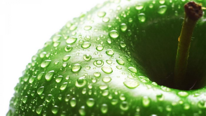 Close-up of a fresh green apple with water droplets