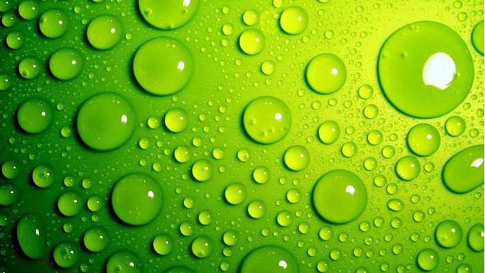 Lime green water drops on a textured surface