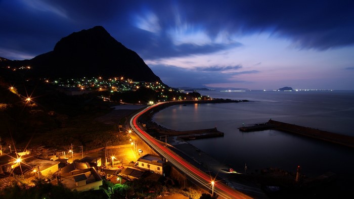 Night landscape of a coastal town with a mountain