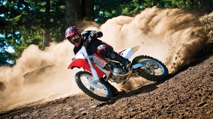 Motocross rider kicking up dust on a dirt track