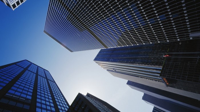 Glass skyscrapers against a clear blue sky