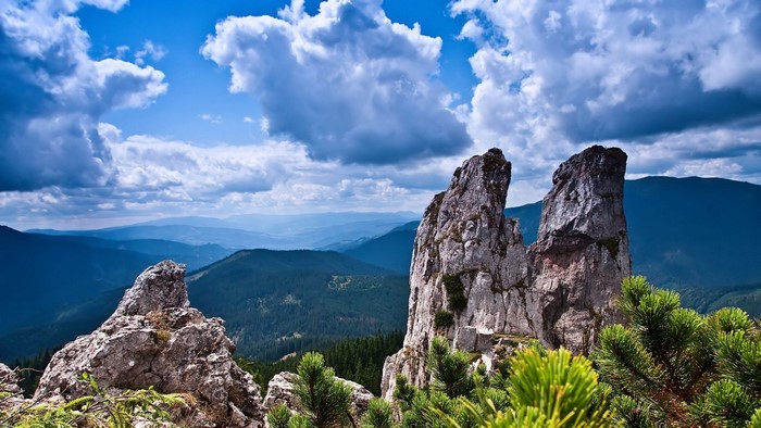 Rocky mountain peaks with green forest and blue sky